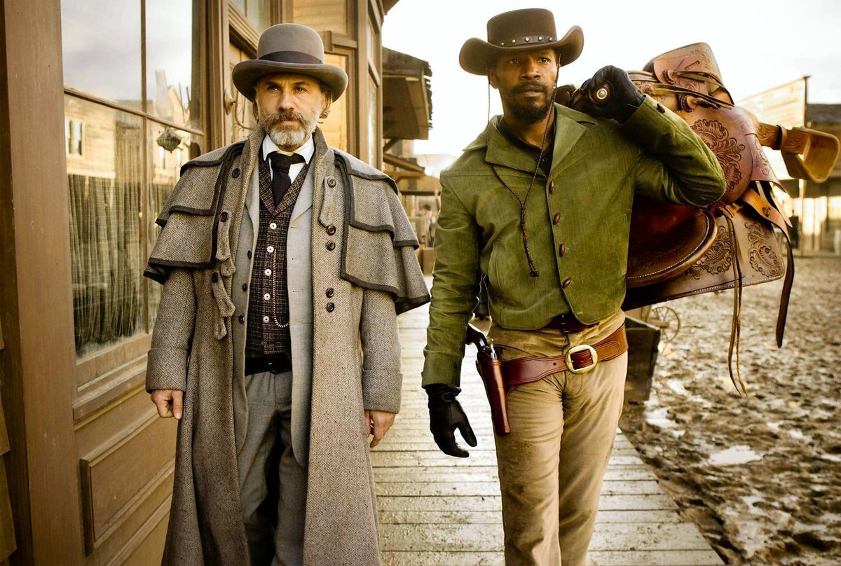 King (Christoph Waltz) and Django (Jamie Foxx) walk down a muddy street in Django Unchained