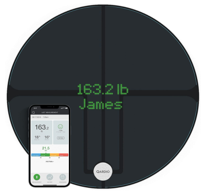 Best smart scale Qardio product image of a black, circular scale with an accompanying smartphone and the weight of someone called 'James' on the display.