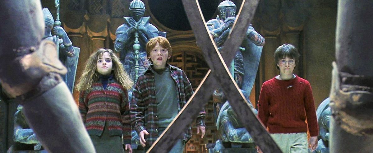 harry, ron, and hermione face off against a giant chess sat in harry potter and the sorcerer’s stone