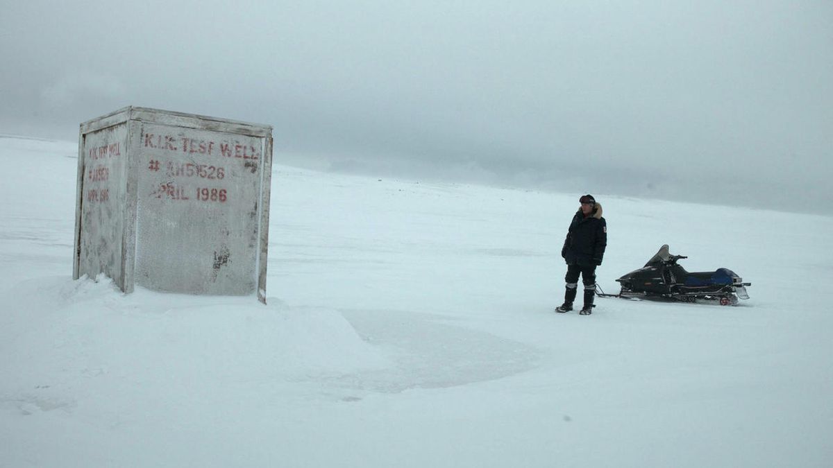 A man standing in front of a white container in the middle of the Antarctic tundra in The Last Winter.