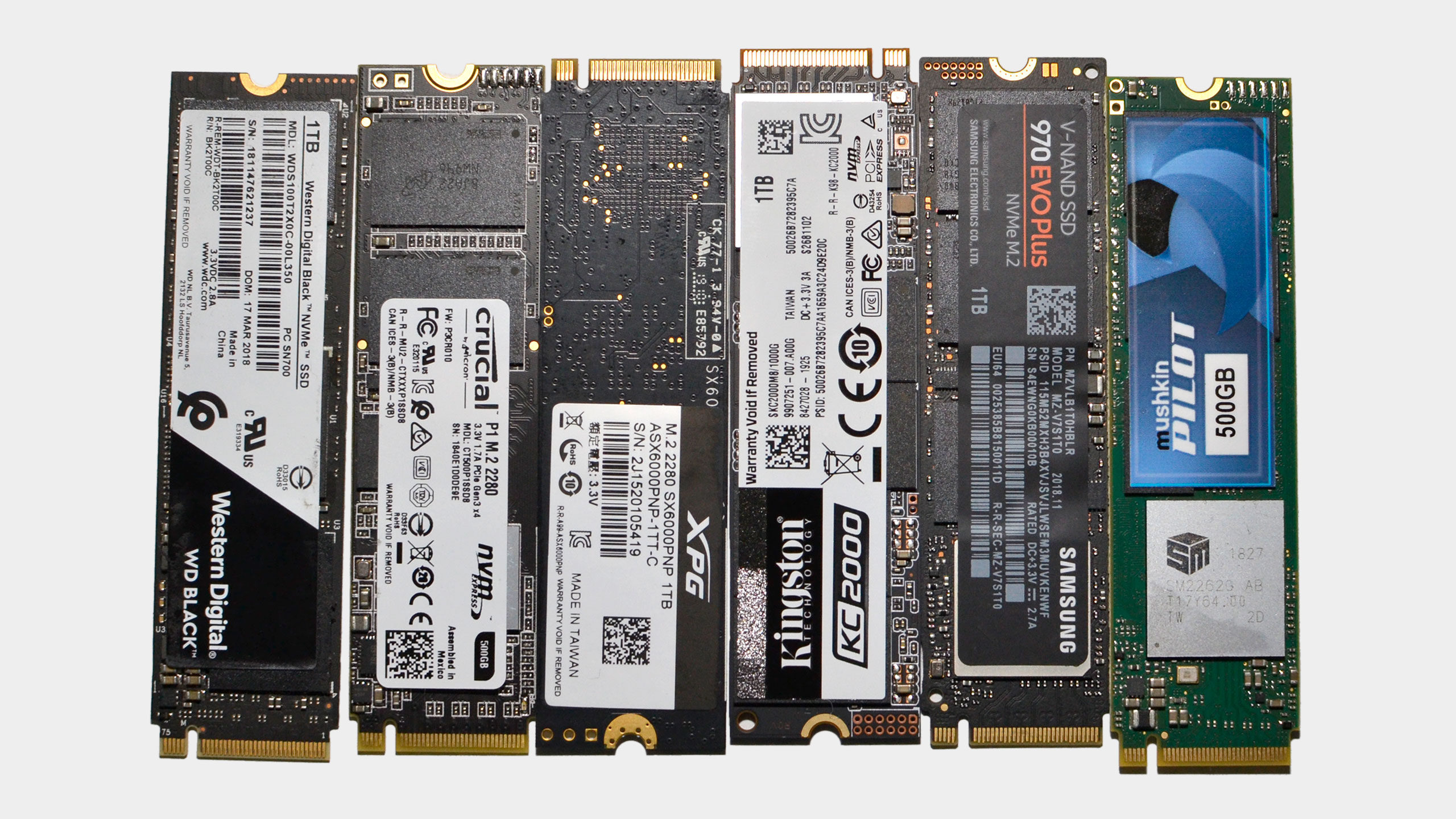 A collection of modern M.2 NVMe SSDs on a grey background
