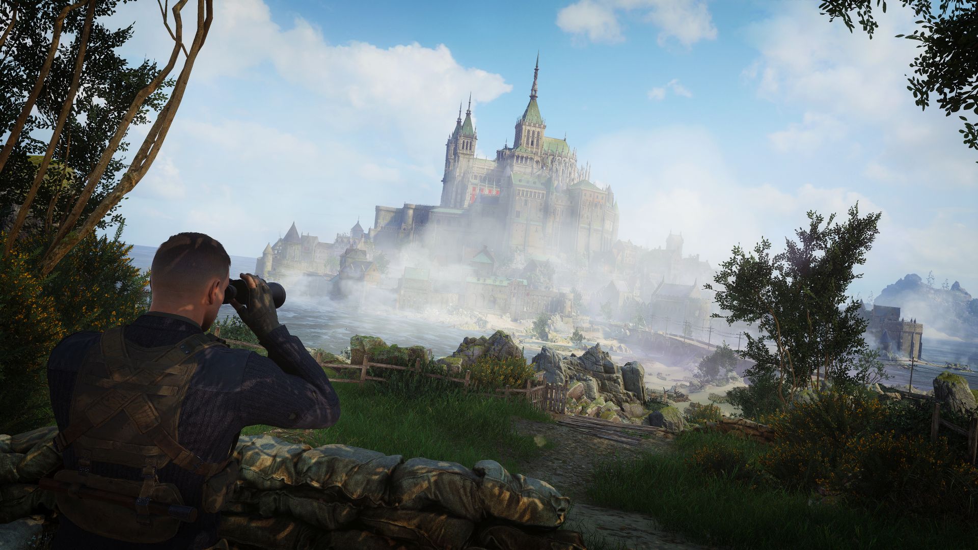 Karl, using binoculars, stands behind a sandbag wall in the shade of trees. He looks out towards an island where a grand Abbey towers above the rest of the buildings. 