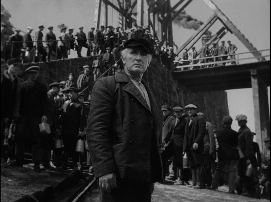 Donald Crisp as Gwilym Morgan in How Green Was My Valley, in front of a line of miners.