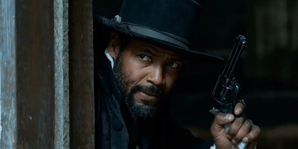 Isaiah Mustafa as Cicero holding a pistol in Murder at Yellowstone City.