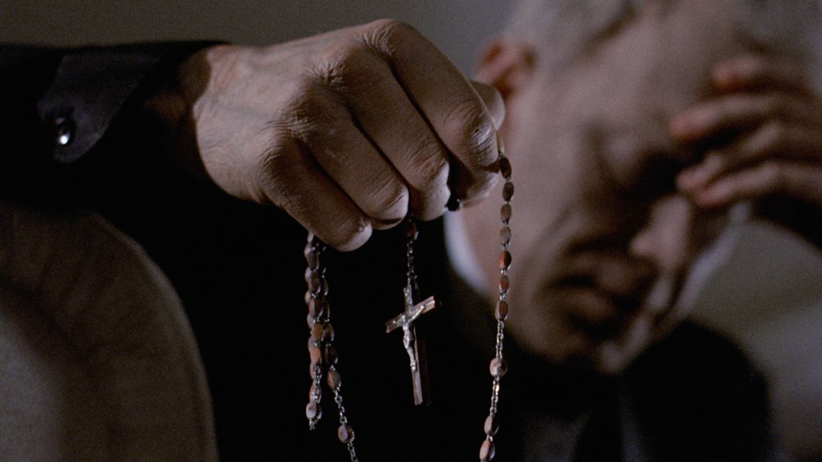 Max Van Sydow holds a cross in one hand and his head in the other in The Exorcist.