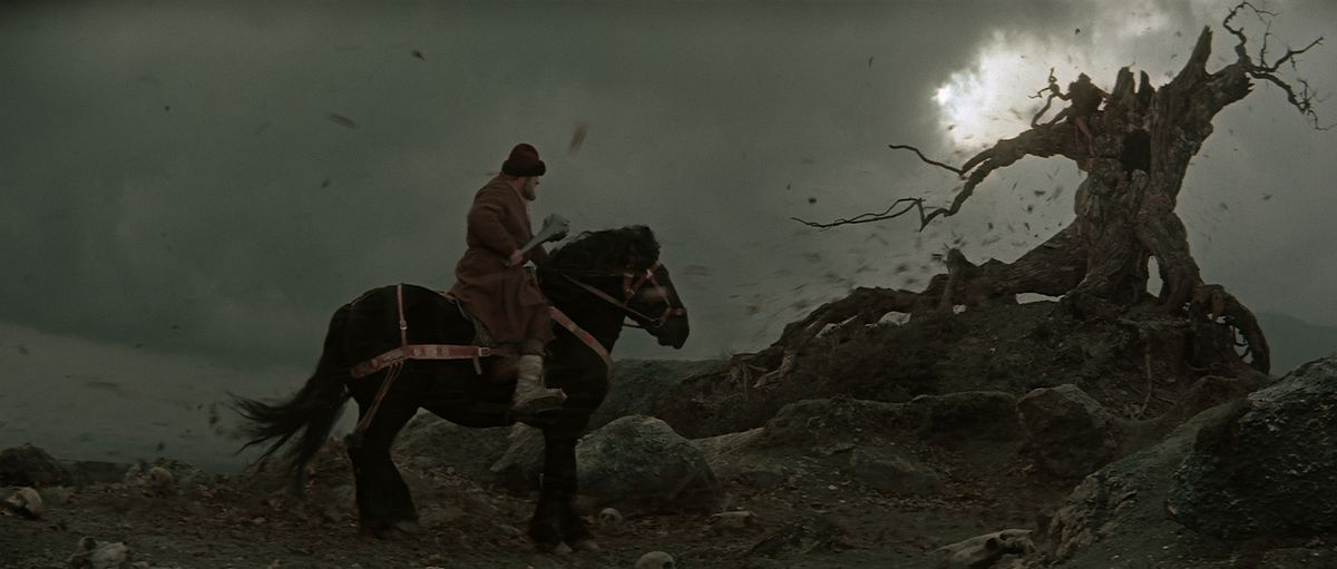 A man on a horse in front of a spooky tree in Ilya Muromets: The Sword and the Dragon.