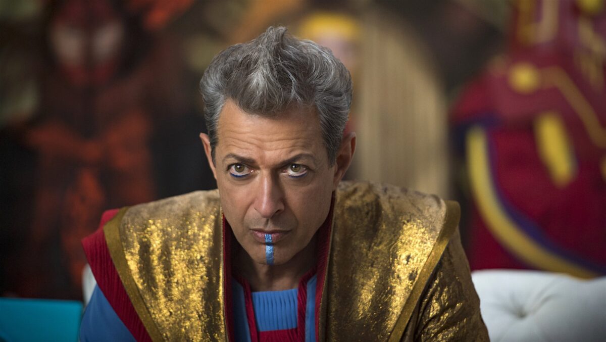 Jeff Goldblum as The Grandmaster in "Thor Ragnarok," wearing gold robes and a strip of blue makeup on his chin paired with a spiky hairdo.