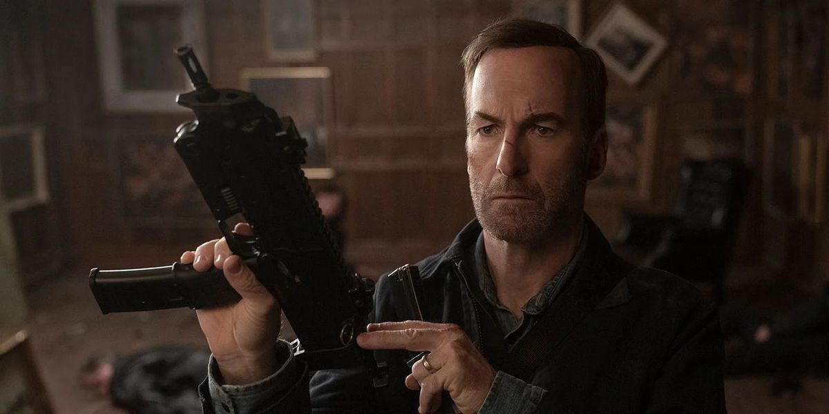Bob Odenkirk looking dishelved, bloodied, and loading a firearm in Nobody