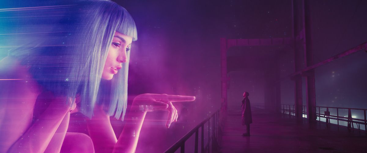 Ryan Gosling standing in front of a hologram in Blade Runner 2049.