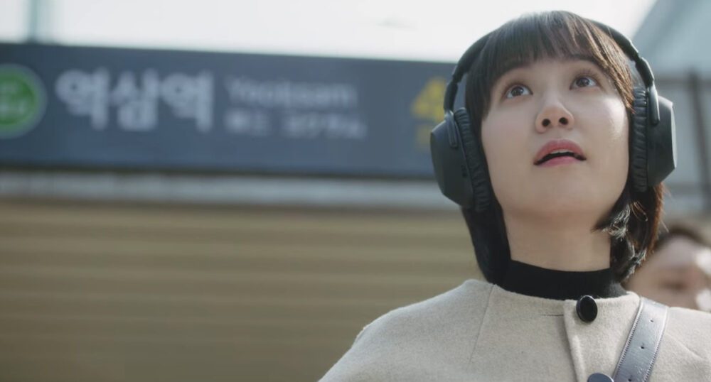 Eun Park-bin as Woo Young-woo looking up at the sky with the subway station sign behind her