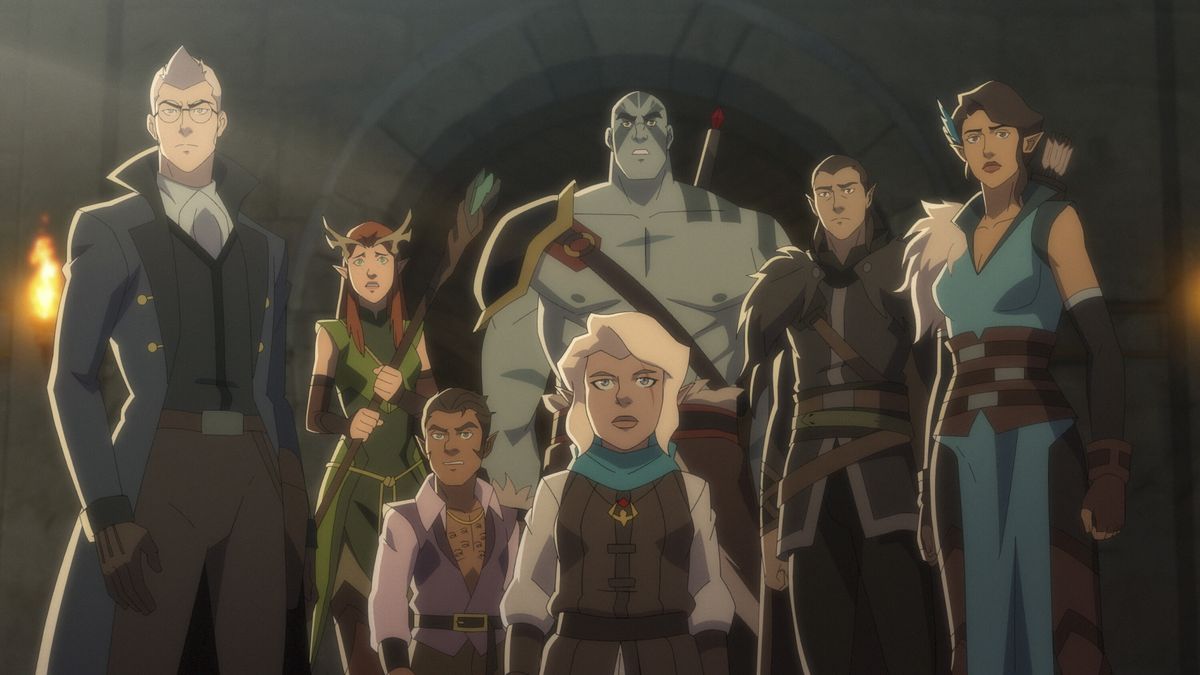 the cast of vox machina, from left to right: percy, a tall pale human in a snappy trench coat; keyleth, a nervous redhaired half-elf clutching a staff; scanlan, a short tanned gnome with a low cut purple shirt; grog, a tall grey-skinned goliath barechested and smiling; pike, a short gnome woman with pale hair; vax, a half-elf rogue with long dark hair and dark clothes; vex, a half-elf ranger clad in blue, a feather in her dark hair and a quiver on her back