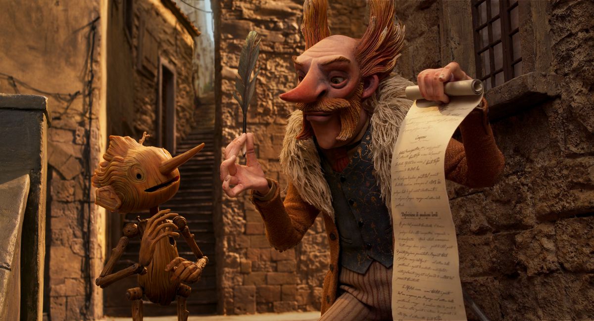Count Volpe holds a piece of paper in front of Pinocchio in Netflix’s Pinocchio, from Guillermo del Toro.