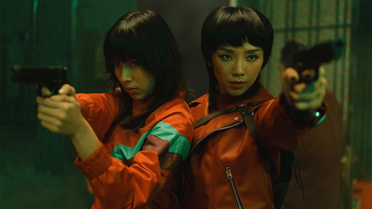 Two young women wearing orange tops stand next to each other and hold pistols in Furies.