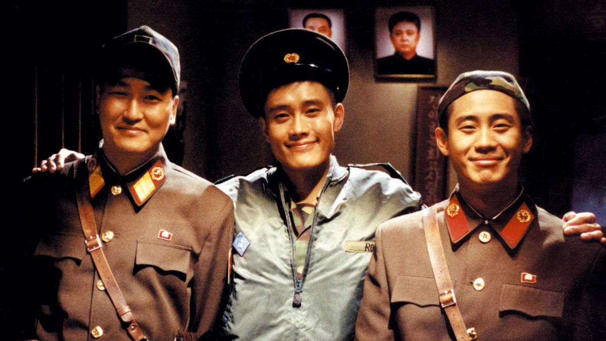 Song Kang-ho, Lee Byung-hun, and Shin Ha-kyun posing for a picture and smiling in Joint Security Area.