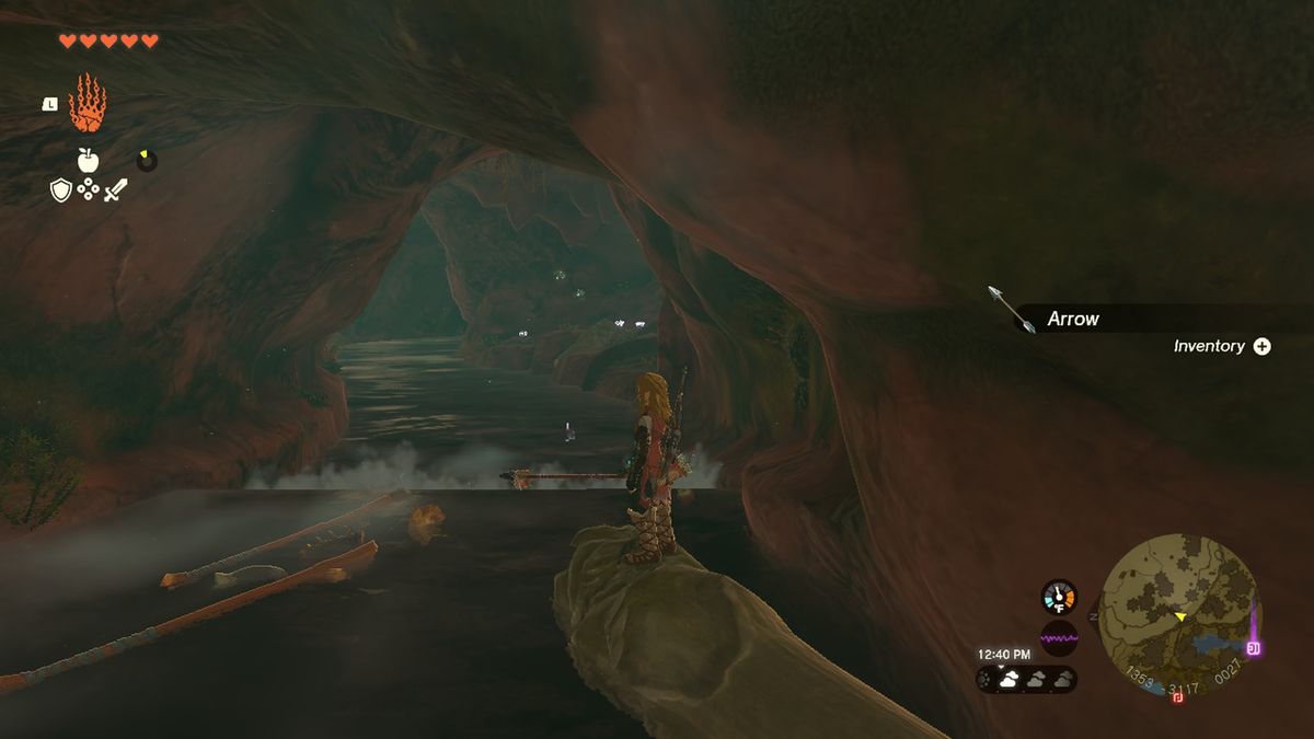 Link rides a log down a river in a cave with the Rubber Armor in Zelda Tears of the Kingdom.