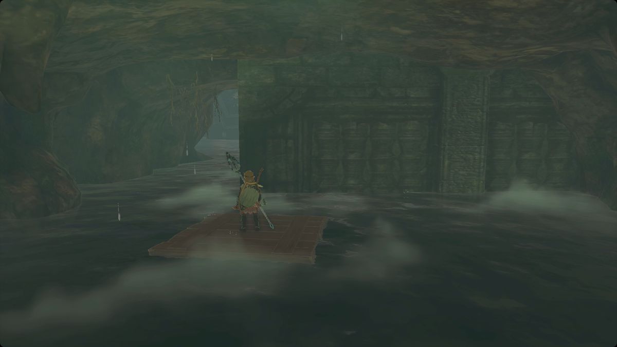 The Legend of Zelda: Tears of the Kingdom Link standing on a floating wood raft in Cape Cales Cliffside Cave