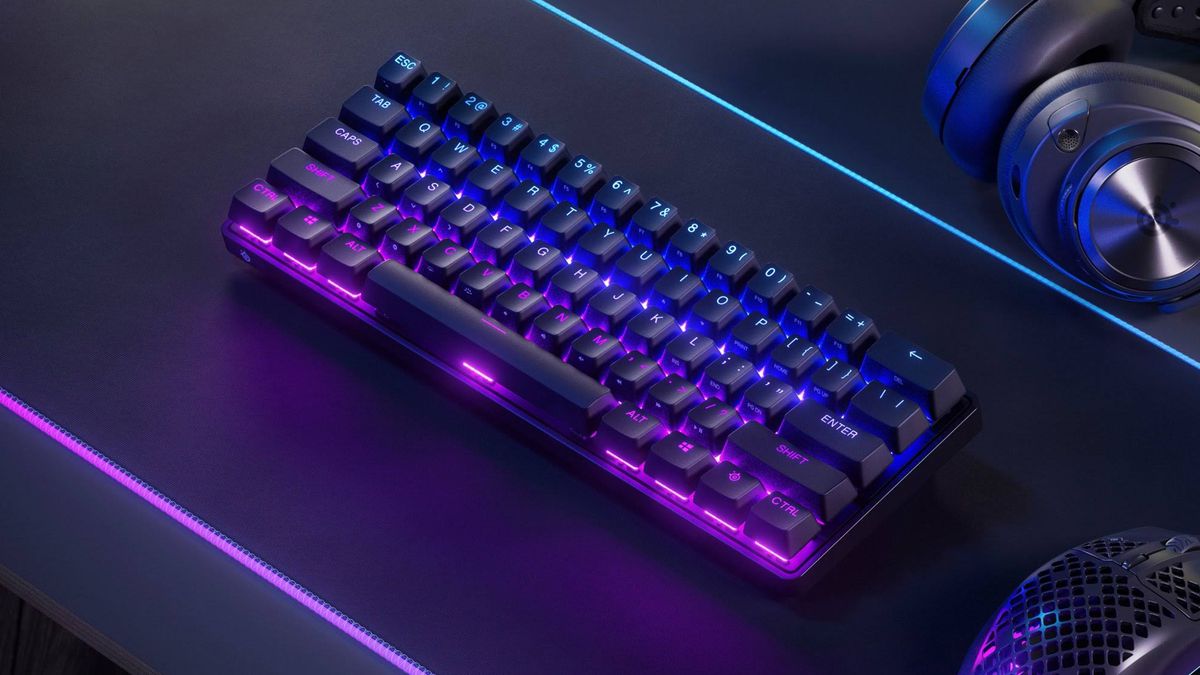 A product photo of the SteelSeries Apex Pro Mini Wireless on top of an RGB mouse mat.