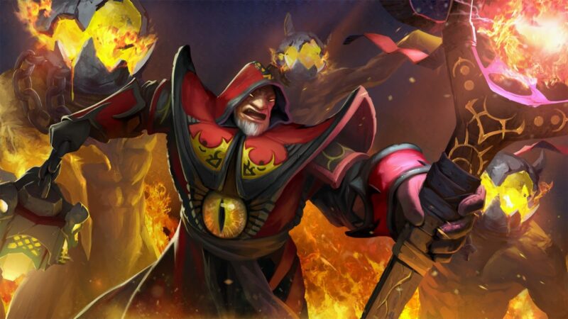 The Dota 2 hero Warlock strides into battle in his red and black hooded robes with his flaming staff at the ready