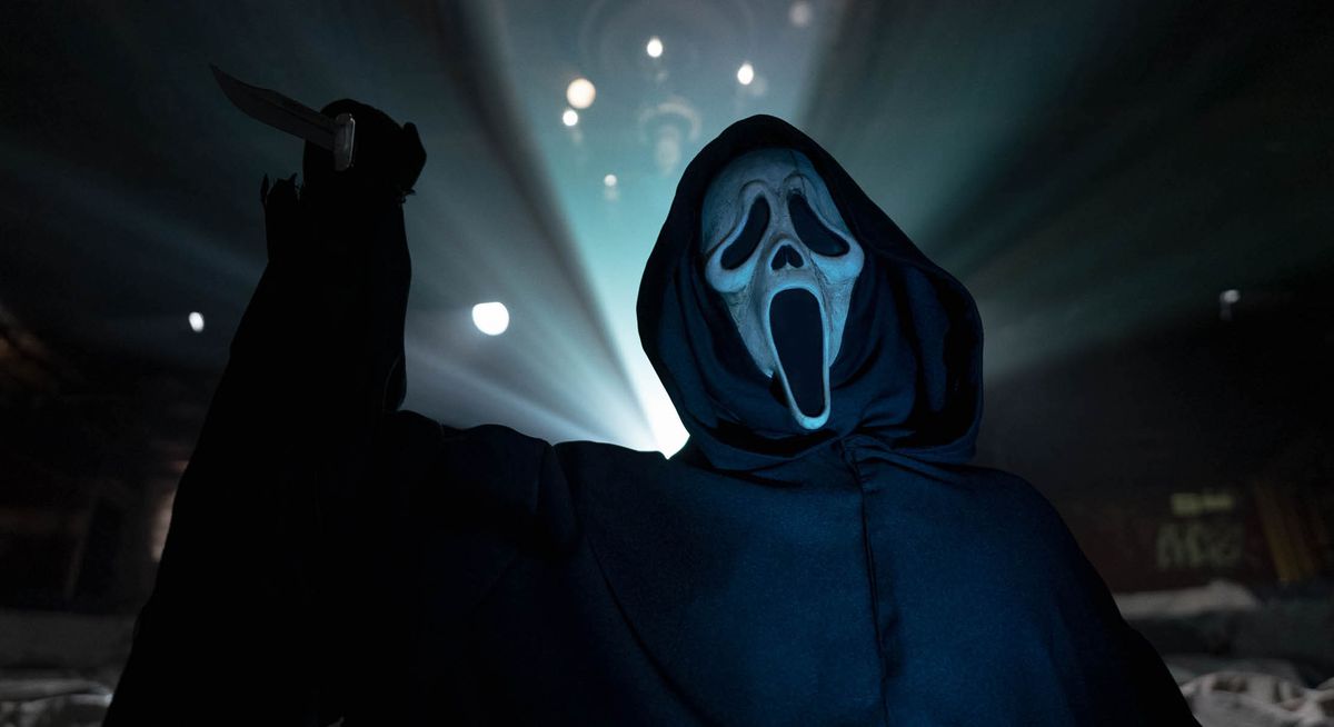 Ghostface, the knife-wielding signature killer from the Scream series, rears up silhouetted against the light of a movie projector in Scream VI.