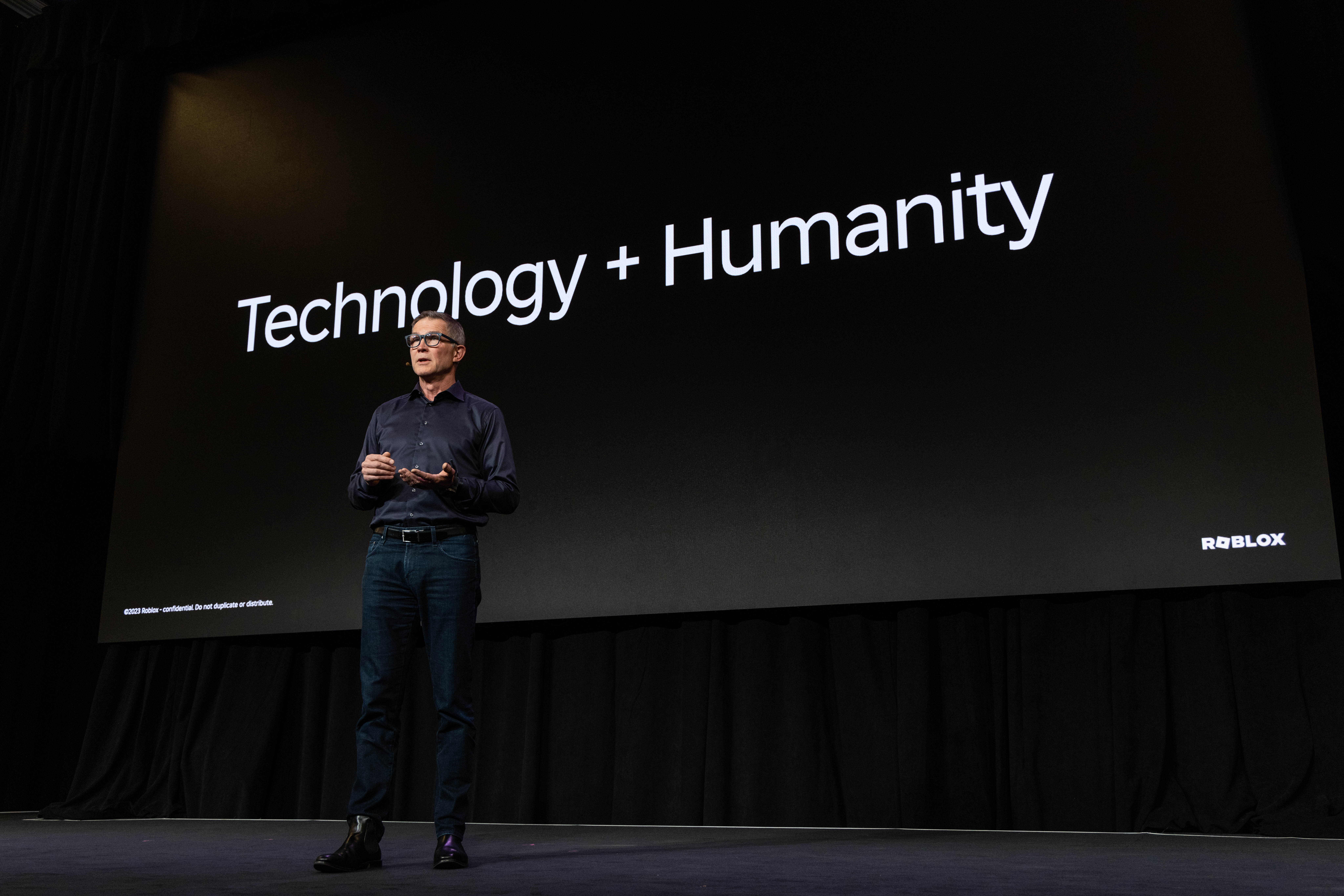 David standing on stage in front of a slide that says Technology + Humanity
