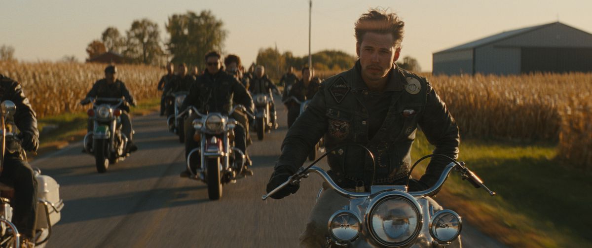 Austin Butler looks amazingly cool as he rides a motorbike one-handed, surrounded by his clubmates, in The Bikeriders