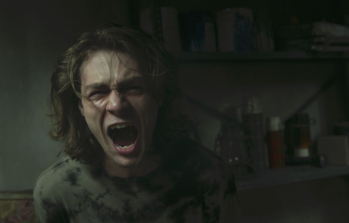 Regular Insidious series character Dalton (Ty Simpkins), now grown into a shaggy-haired teenager, screams in a dark, dreary room in Insidious: The Red Door