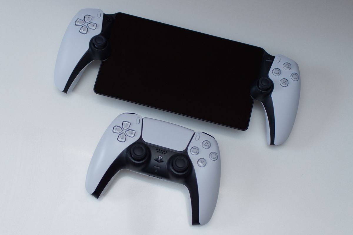 An overhead shot of a powered-down PlayStation Portal, above a DualSense controller for scale
