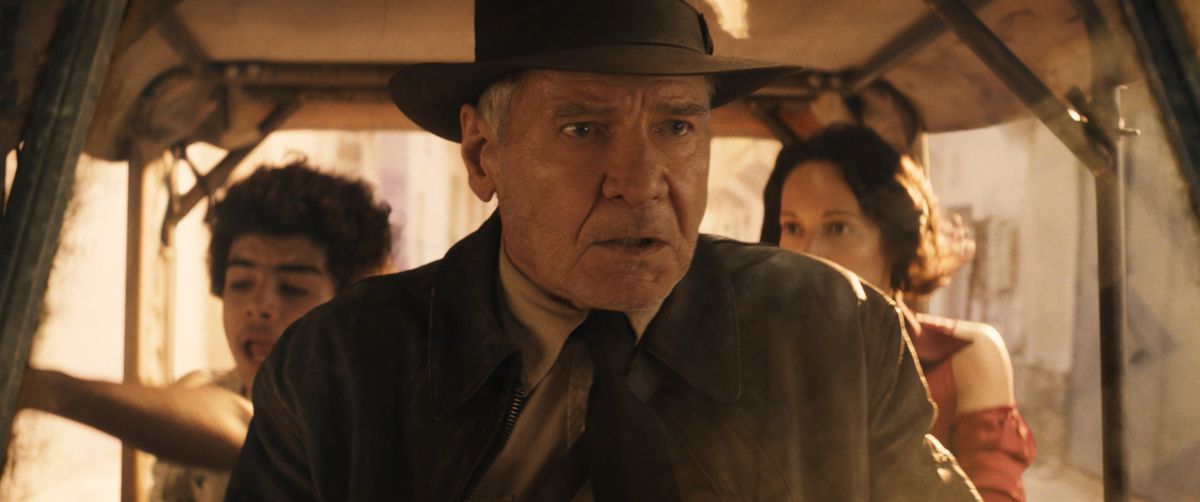 Indiana Jones looks panicked as he drives a cart with Helena and Teddy in the backseat in Indiana Jones and the Dial of Destiny