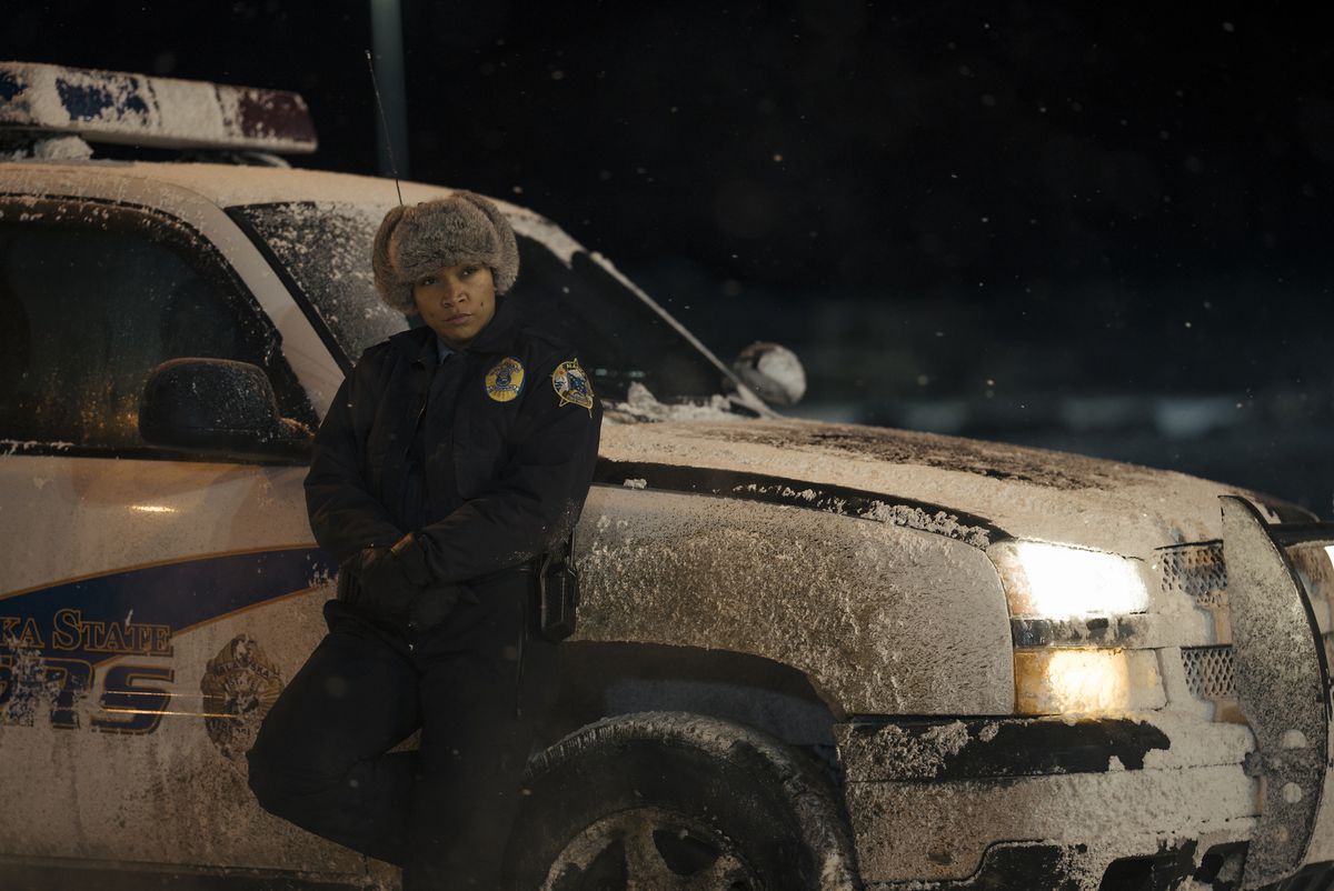 Kali Reis leans against a cop SUV in a parka and furry hat as Officer Navarro in True Detective: Night Country