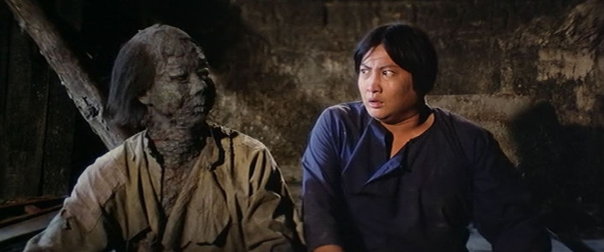 سامو هونگ و یک خون آشام با صورت خاکستری در فیلم Encounters of the Spooky Kind به صورت متعجبانه به یکدیگر نگاه می کنند.