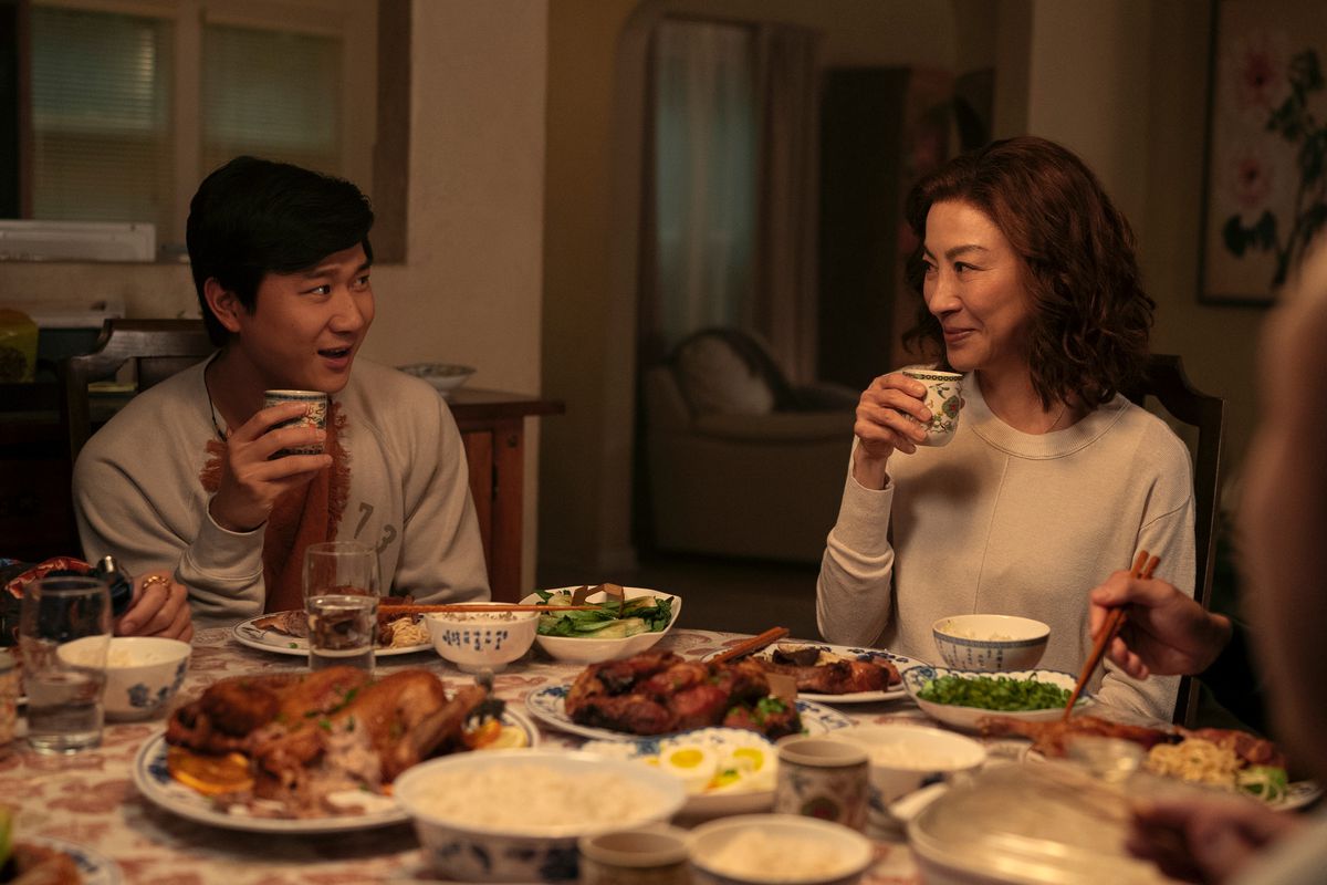 Bruce Sun (Sam Song Li) and his mother Eileen (Michelle Yeoh) sip tea in front of an incredible dinner spread in The Brothers Sun