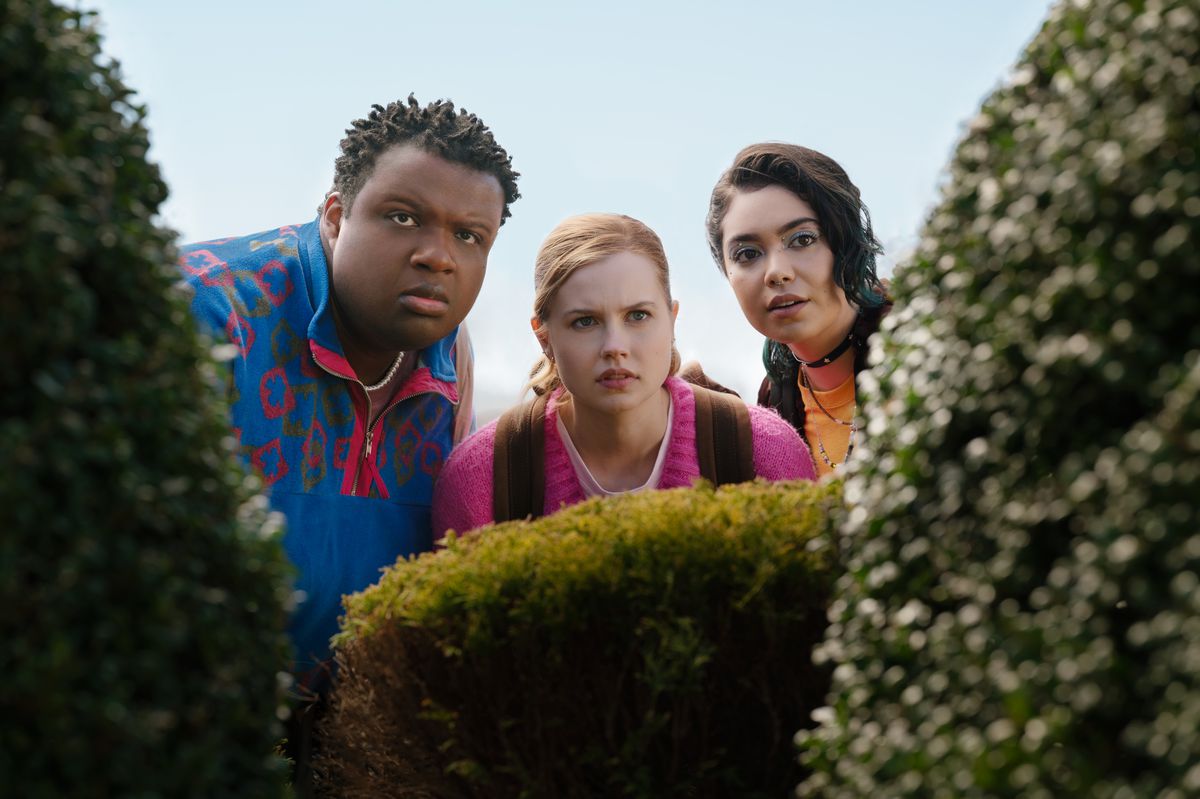 Damien, Cady, and Janis peering through a hedge in Mean Girls (2024)