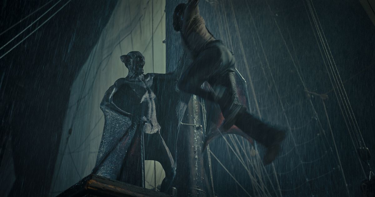 Dracula, looking like a hairless humanoid bat, stands atop a ship’s crows nest in a dark rainstorm, hoisting a poor man up above him.