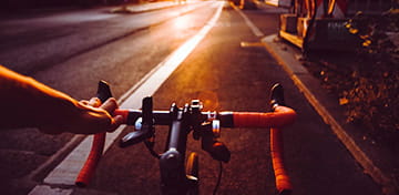 تصویری که نمای جلویی یک دوچرخه سوار در جاده را نشان می دهد