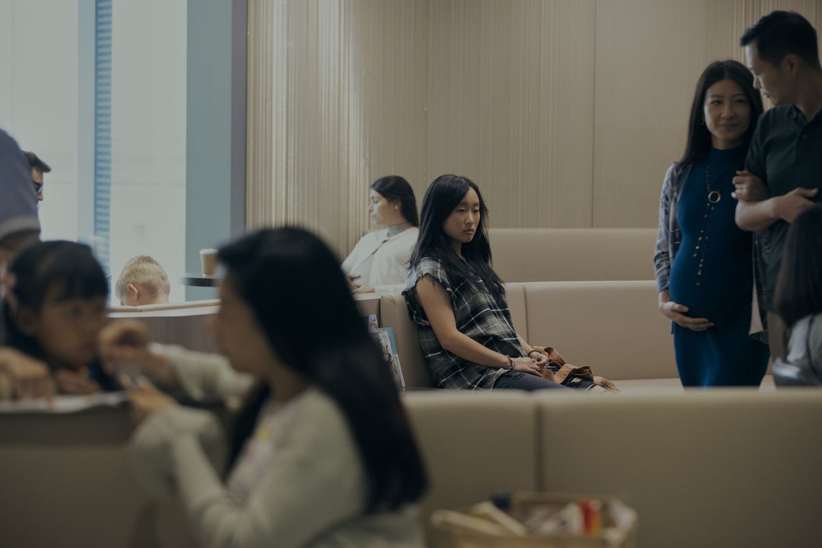 Mercy (Ji-young Yoo) sitting in a waiting room alone