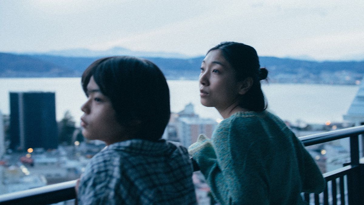 Sakura Andō and Sōya Kurokawa lean on a railing over a cityscape in Monster