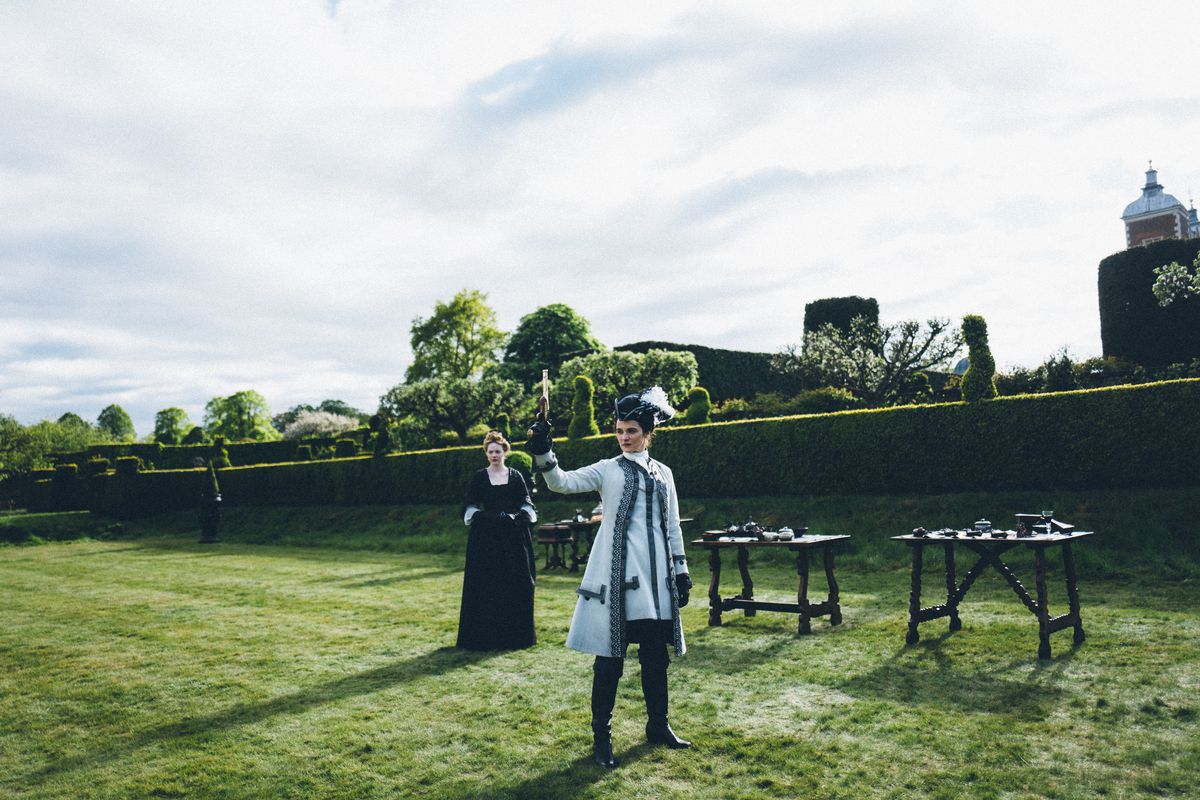 Rachel Weisz fires a gun while Emma Stone looks on in The Favourite
