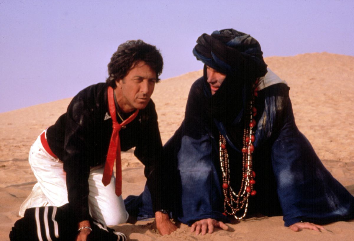 Dustin Hoffman and Warren Beatty crouch in the sand in the Moroccan desert in Ishtar