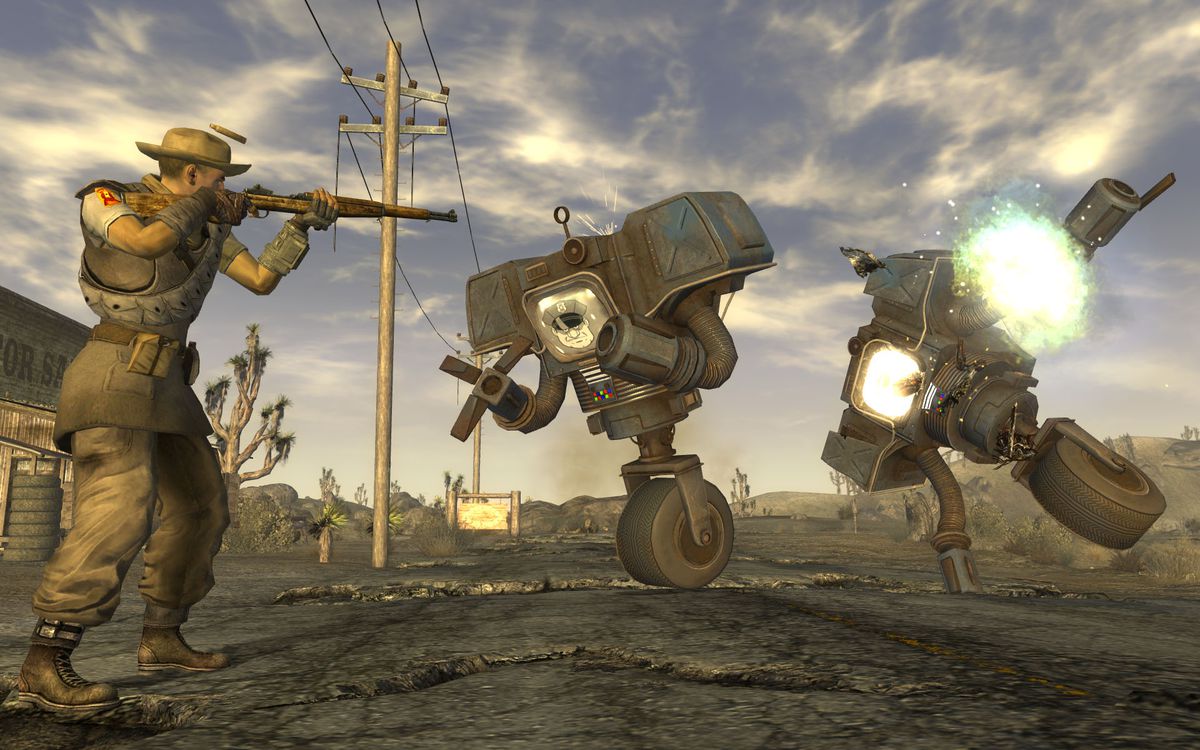 A player in Fallout: New Vegas confronts two security automotons, bulky robots with grasping hands that balance on one wheel, with a rifle.