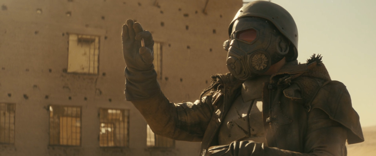 Adam the Lead Farmer (Erik Estrada) ใน Fallout ถือปลอกกระสุนและตรวจสอบมัน เขาสวมชุดจัดส่ง Fallout New Vegas