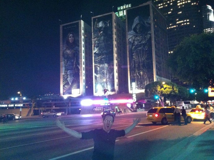 A young Ian Higton posing in front of some large The Elder Scrolls Online artwork at E3 2012.