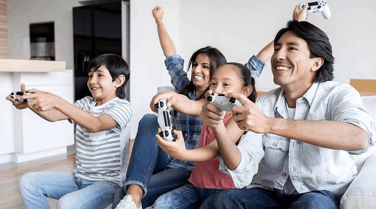 An image showing a family of four having fun, playing video-games together. Used to depict the casual gaming audience in a positive light