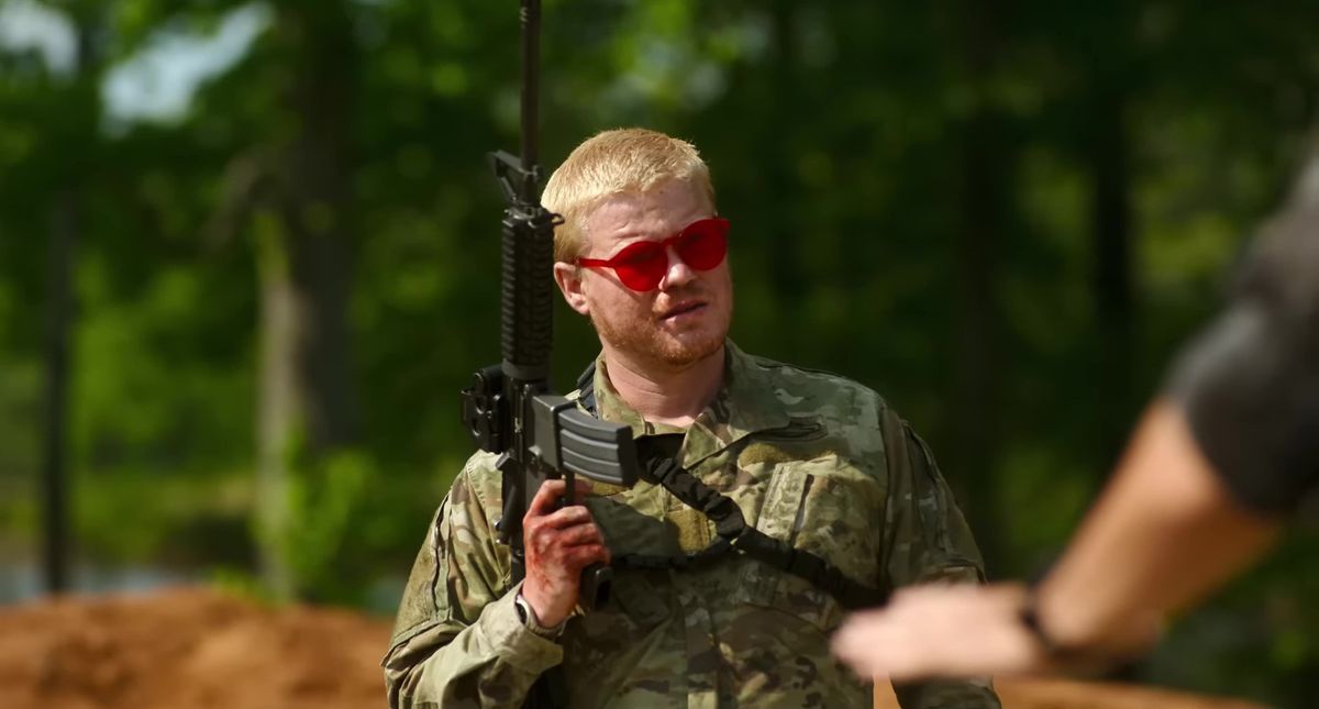 남북 전쟁에서 군복과 빨간색 선글라스를 착용하고 소총을 들고 있는 제시 플레몬스(Jesse Plemons)